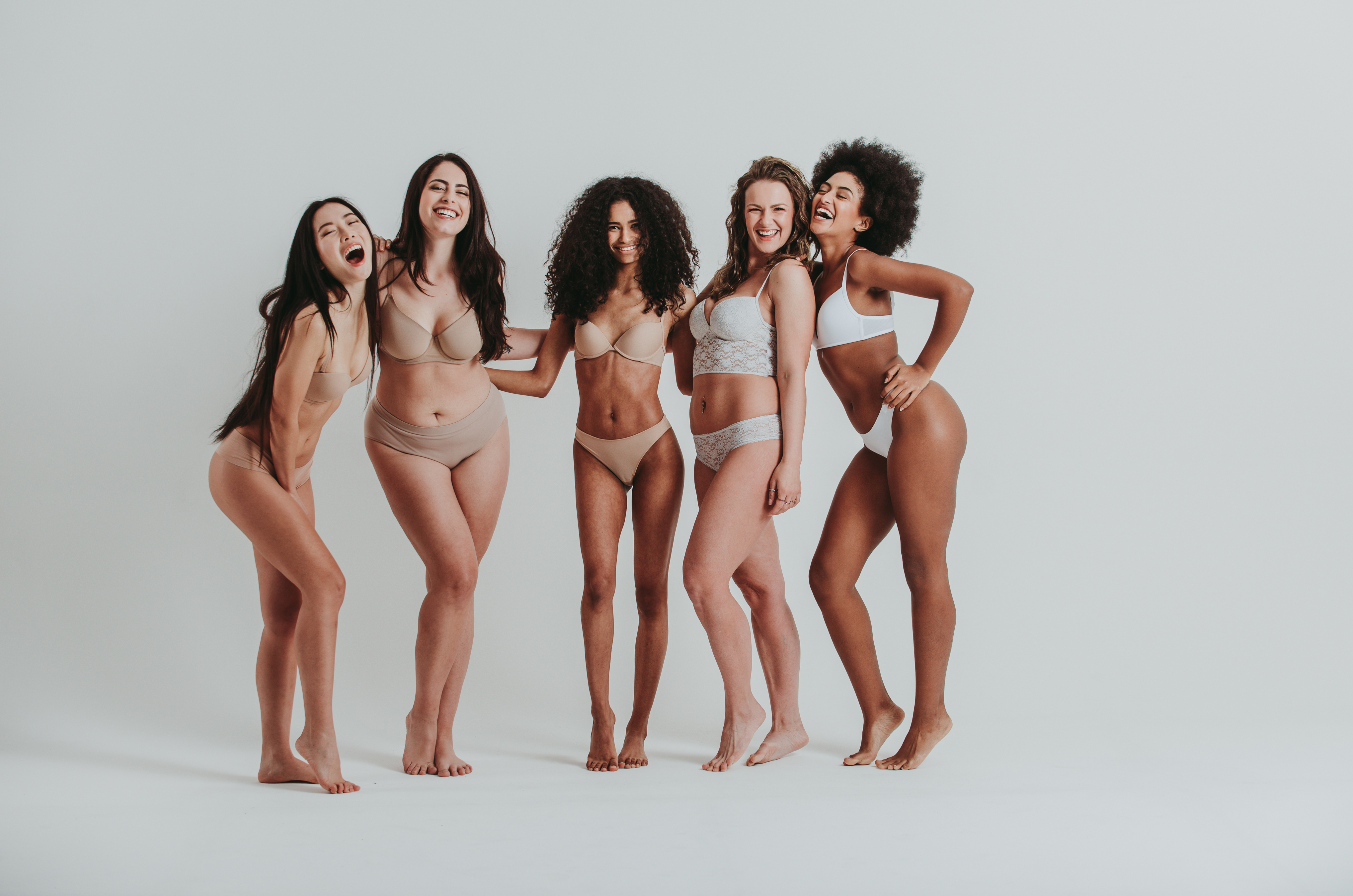 5 Frauen stehen in Unterwäsche vor einem hellgrauen Fotohintergrund